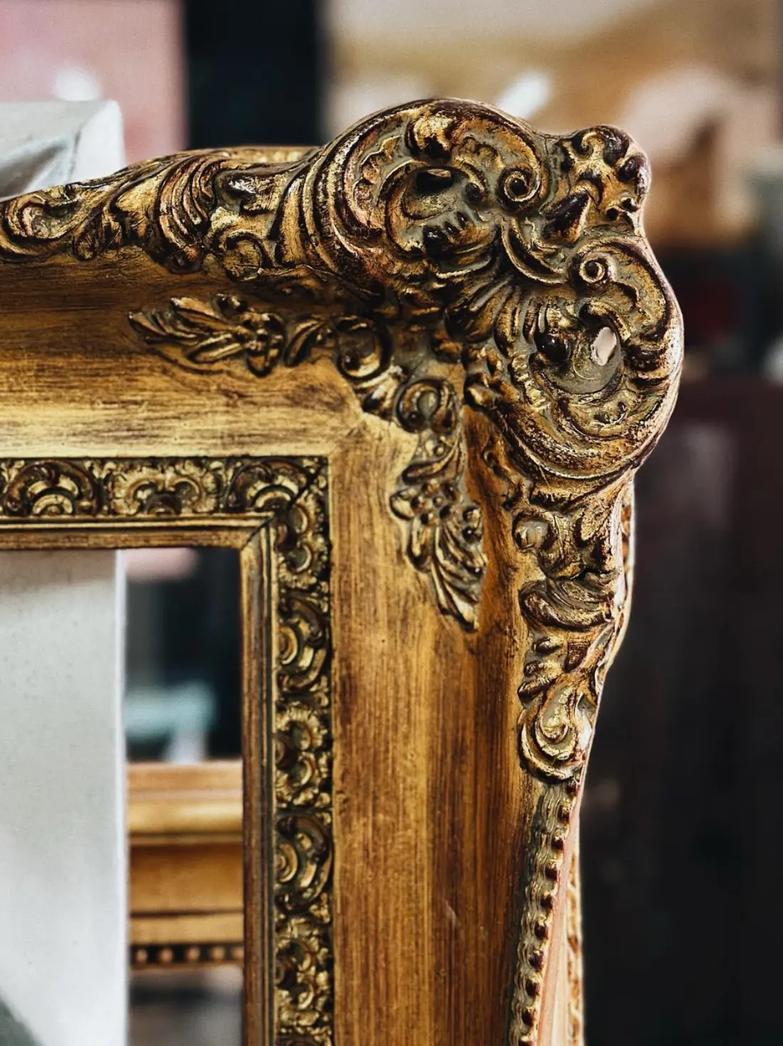 Detall de la cantonada d'un marc daurat amb talla ornamental.